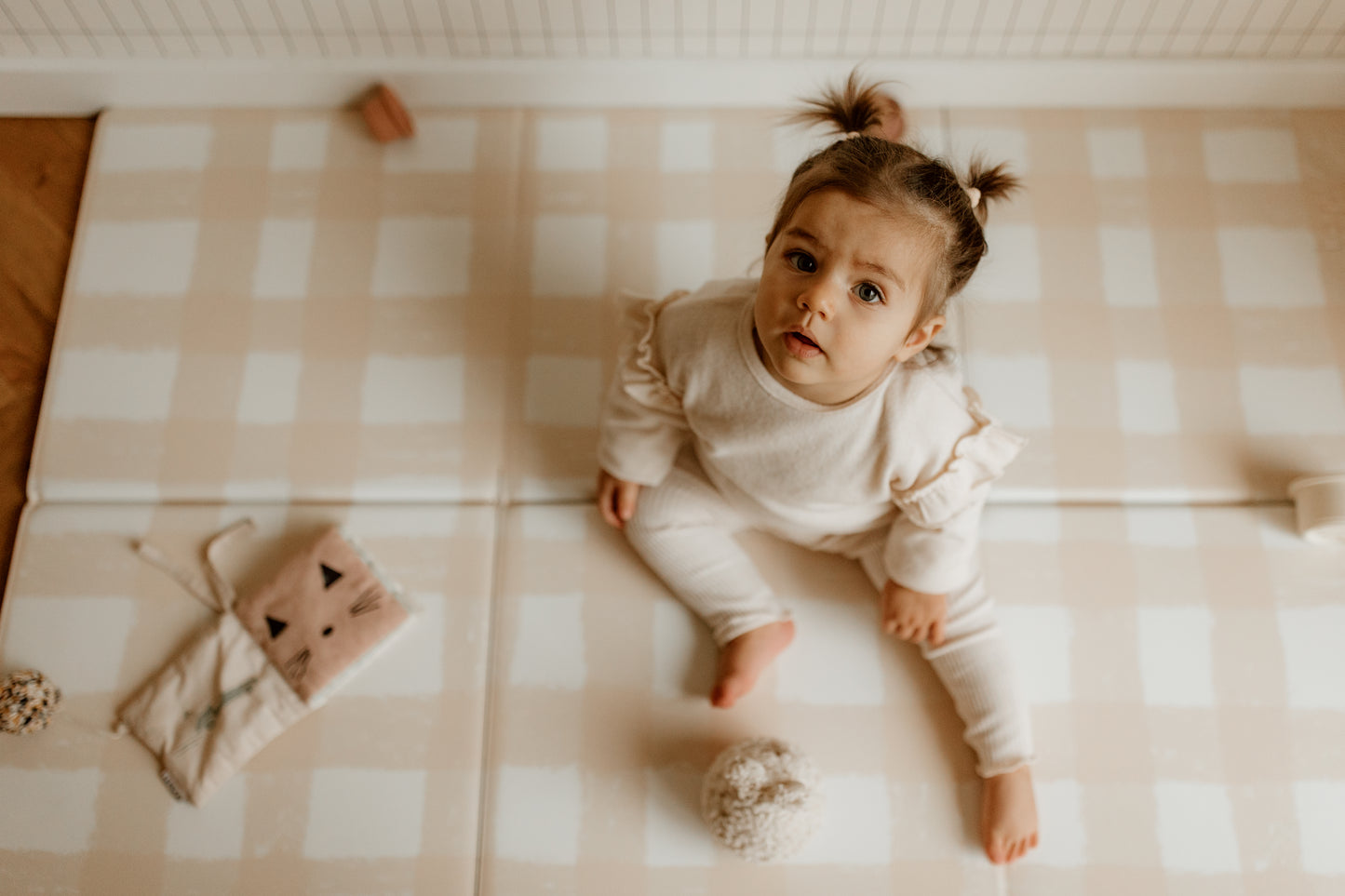 petite fille assise sur le tapis de jeu le pêche mêle tapilou