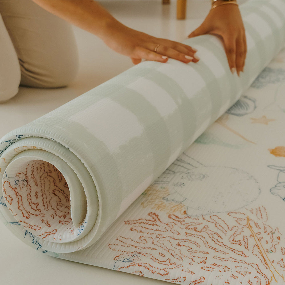 personne en train d'enrouler le tapis de jeu xl le lagoon