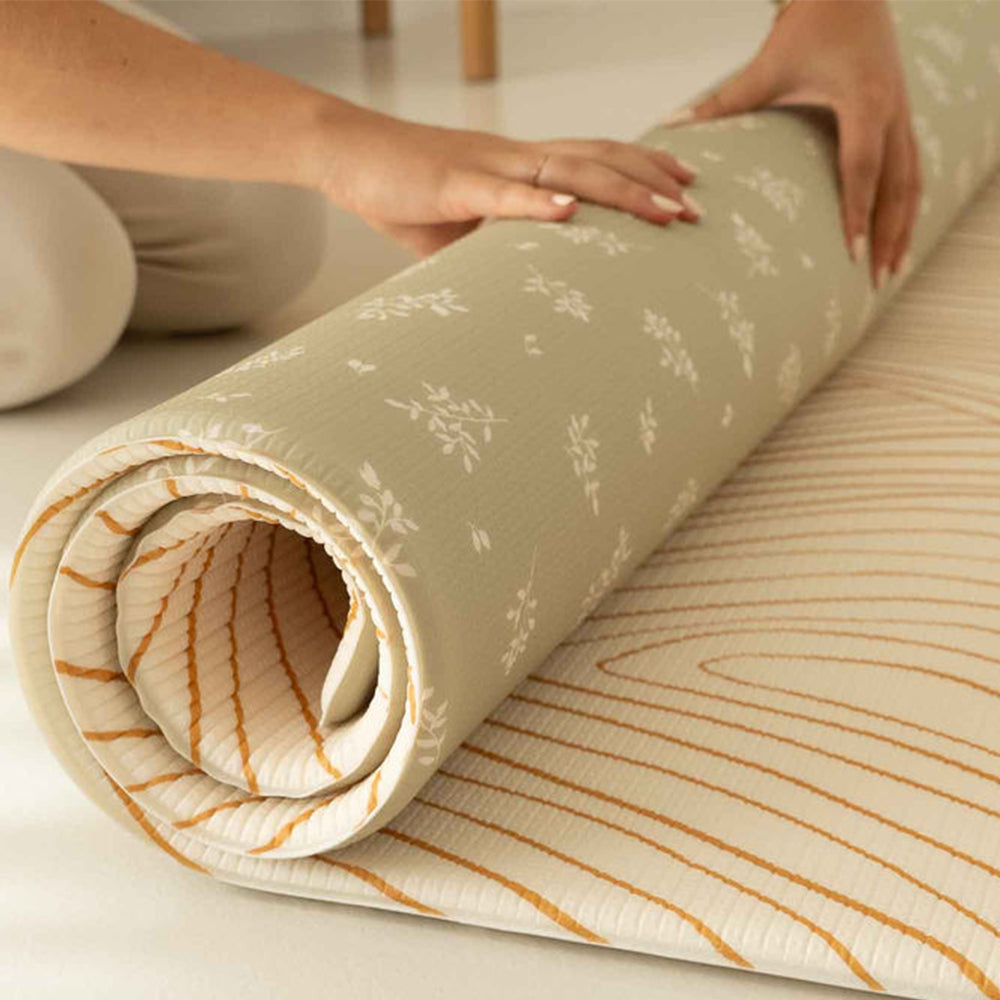 Personne en train d'enrouler le tapis de jeu xl l'oasis