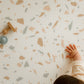 zoom avec main bébé tapis de jeu motif terrazzo