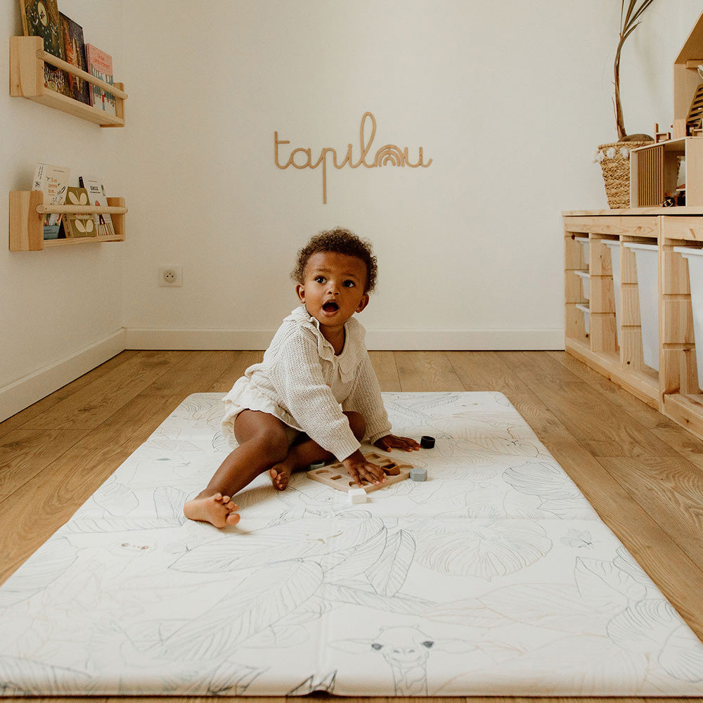 bébé sur le tapis de jeu pliable motifs savane