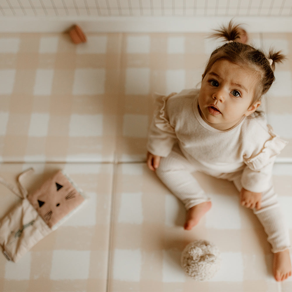 bébé sur le tapis de jeu pliable motif vichy beige