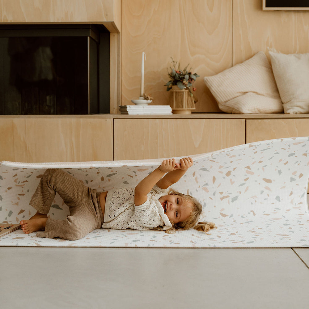 enfant rigolant sur le tapis de jeu granite tapilou