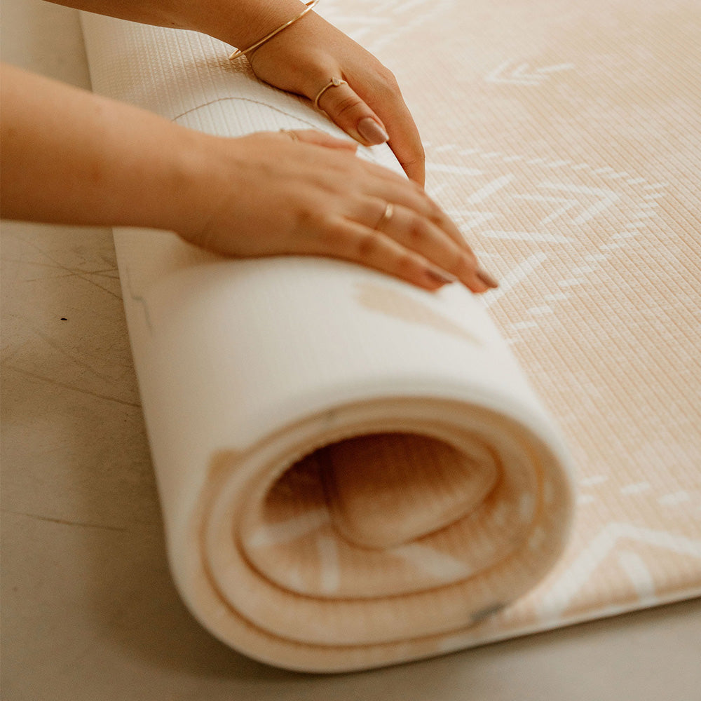 personne en train d'enrouler le tapis de jeu xl le bohème