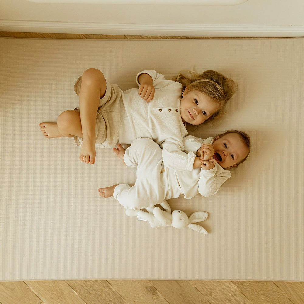 enfants sur le tapis de jeu L uni beige tapilou