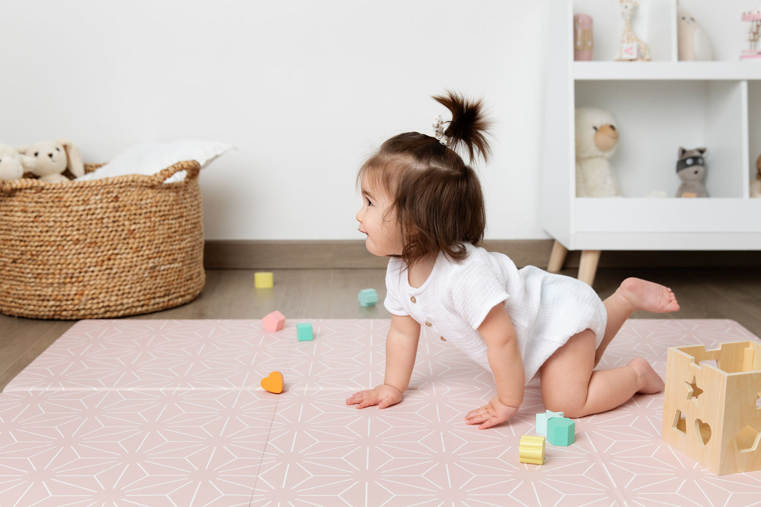 petite fille qui marche à quatre pattes sur le tapis de jeu le flamingo