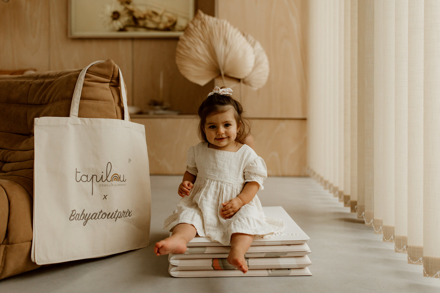 bébé assis sur le tapilou en mode pouf avec le tote bag tapilou x babyatoutprix