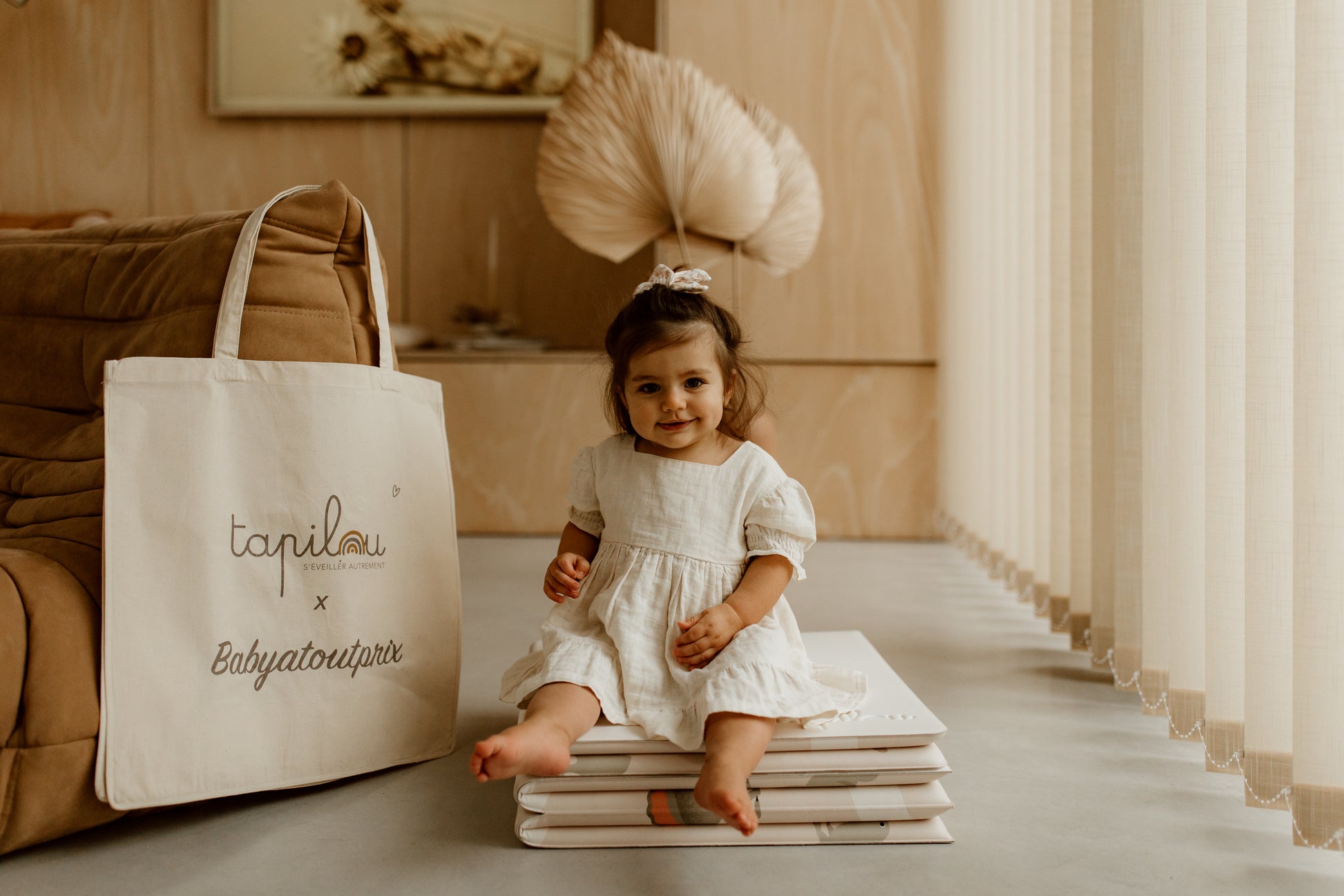 bébé assis sur le tapilou en mode pouf avec le tote bag tapilou x babyatoutprix