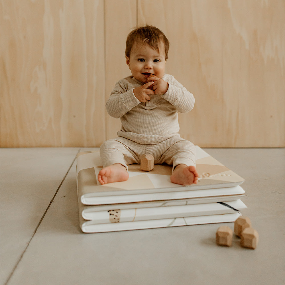 bebe assis sur le tapilou pliable le gribouille en mode pouf