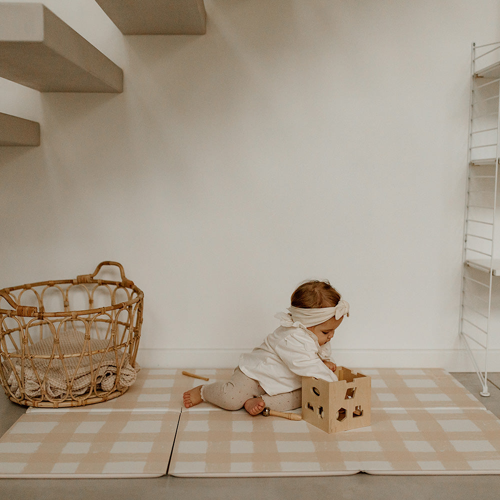 bébé sur le tapis de jeu pliable le pêche-mêle