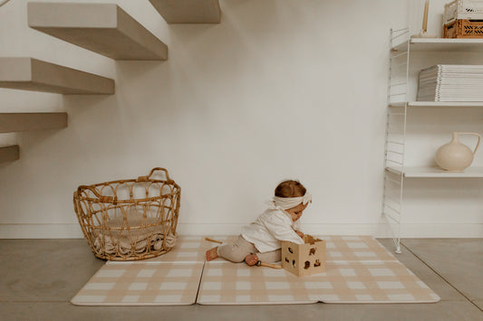 bébé qui joue avec des jouets en bois sur le tapis de jeu tapilou