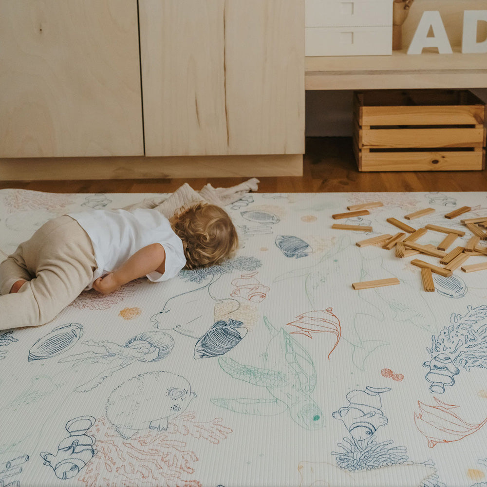 bébé allongé sur le tapis de jeu grand format animaux de la mer