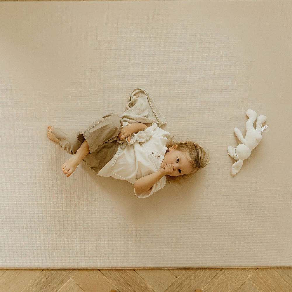 Enfant sur le tapis de jeu léo face uni tapilou