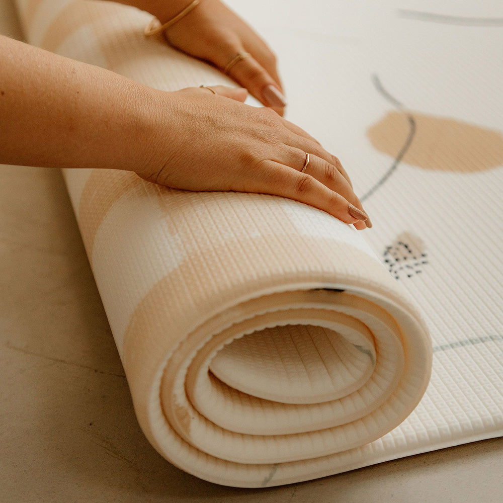 personn en train d'enrouler le tapis de jeu xl le vichouille tapilou