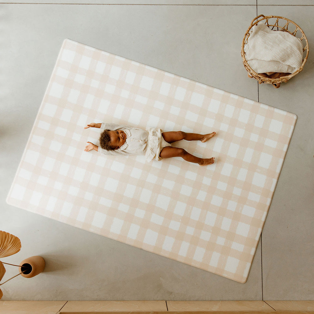 enfant allongé sur le tapis de jeu xl motif vichy